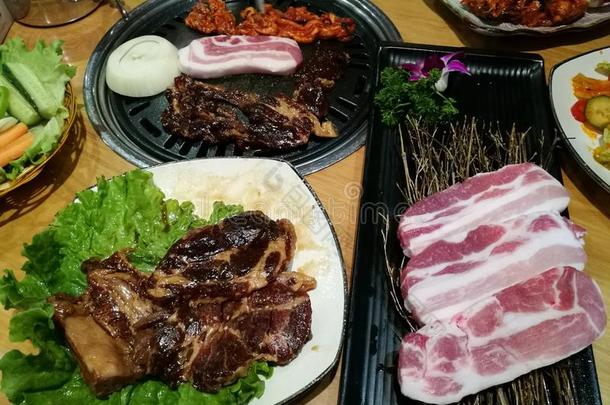 烤猪肉片在热烧烤锅，家庭晚餐时间，韩国食物，Yakiniku，韩国小镇