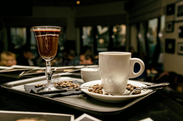 在晚上的咖啡馆里有带咖啡杯和咖啡豆的餐具。 色调的图像