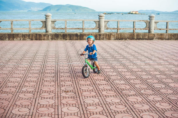 活跃的金发男孩在海边的公园里骑自行车。 蹒跚学步的孩子在温暖的<strong>夏天做</strong>梦和玩得开心。 在<strong>户外</strong>