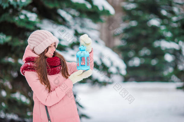 美丽的女人在美丽的<strong>冬季雪天</strong>在户外拿着圣诞烛光