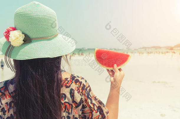 美丽的女人，带着新鲜的西瓜，手里拿着热带海滩-夏天的假期