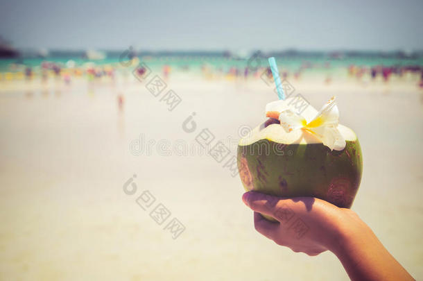 新鲜椰子鸡尾酒与女人手在热带海滩-夏天的假期