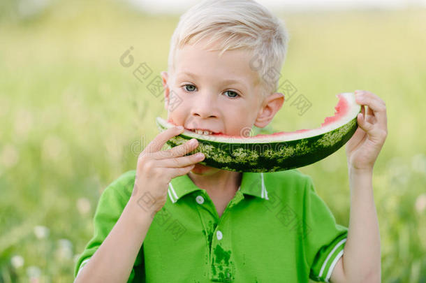 可爱的小男孩，金发在<strong>夏末</strong>花园吃西瓜