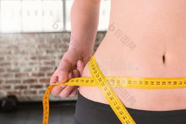 健身妇女腰部谁正在测量她的大小在健身房