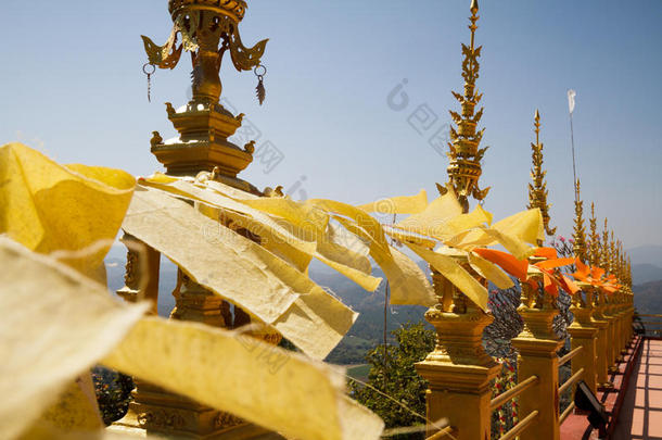 在泰国寺庙中飘扬和挥舞黄色和橙色的佛教旗帜，以天空为背景