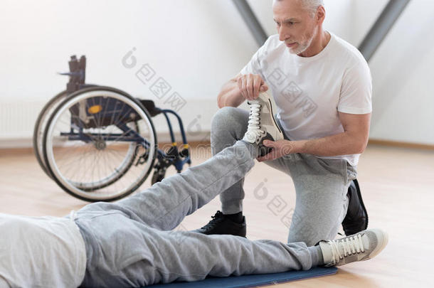 集中老年骨科医生在健身房帮助残疾病人