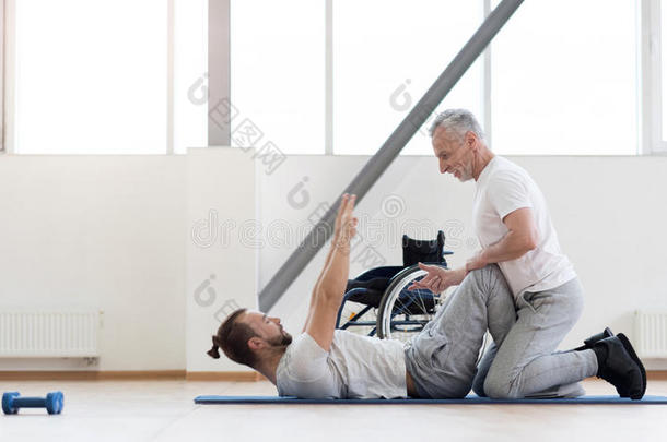 有经验的积极骨科医生在健身房帮助残疾人