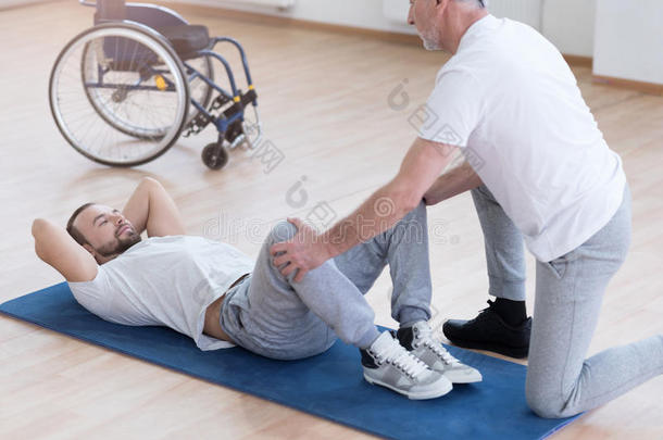 老年全科医生在体育馆里为残疾人做伸展运动