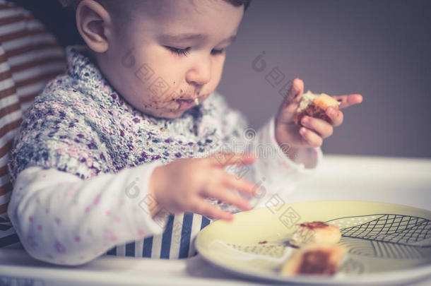 满脸<strong>脏乱</strong>的婴儿吃奶酪蛋糕