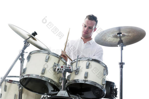 鼓手在鼓组后面穿白色衬衫，打鼓
