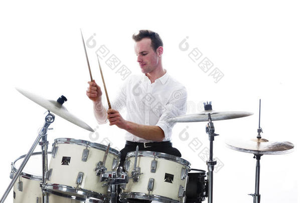鼓手在鼓组后面穿白色衬衫，<strong>打鼓</strong>