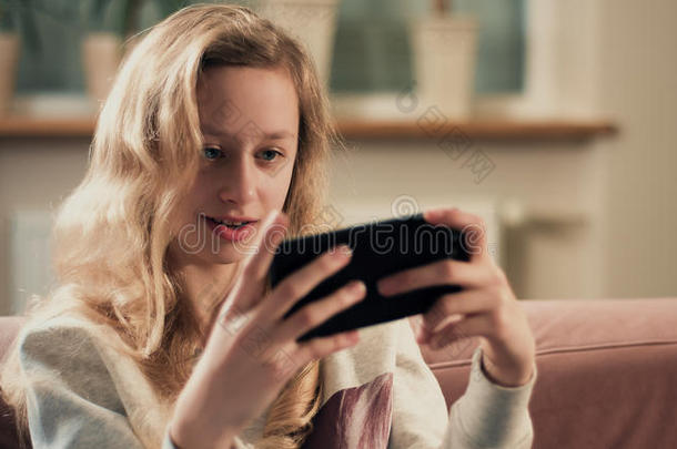 女孩在连接到LTE互联网的智能手机上玩游戏