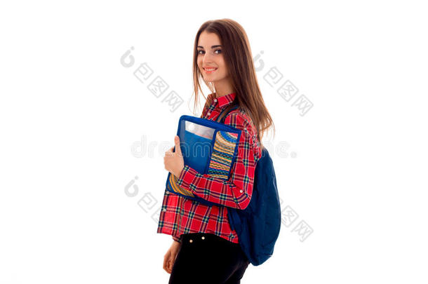 兴高采烈的年轻女学生<strong>背着书包</strong>，夹着笔记本，看着相机，微笑着孤立在白色的身上