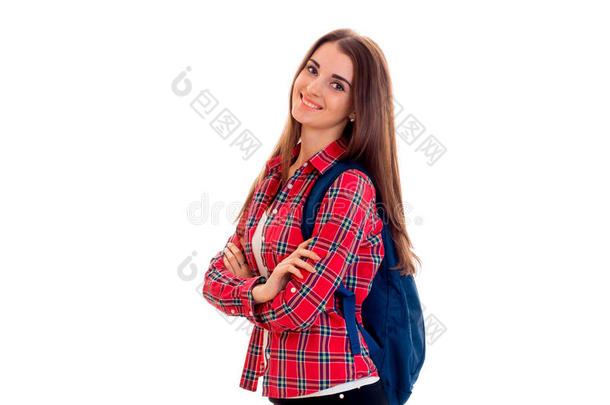 开朗的年轻学生女孩带着背包看着相机，微笑着孤立在白色的背景上。 学生年