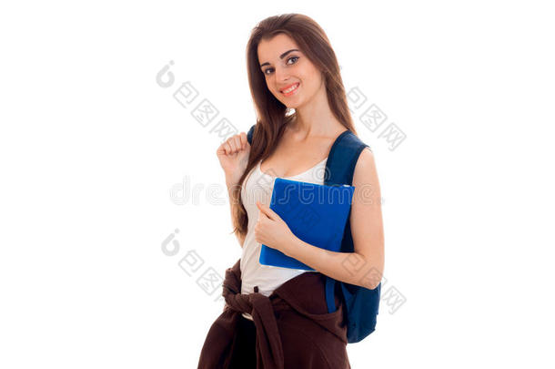 开朗的年轻学生女孩，带着背包和书，在白色背景上隔离的相机上微笑。 学生年