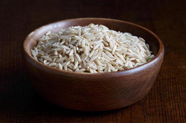 干长粒糙米在棕色木碗。
