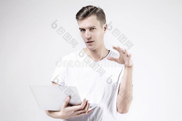 迷人的商务<strong>男士</strong>模型，白色t<strong>恤</strong>，与笔记本电脑隔离，左手拿着东西。