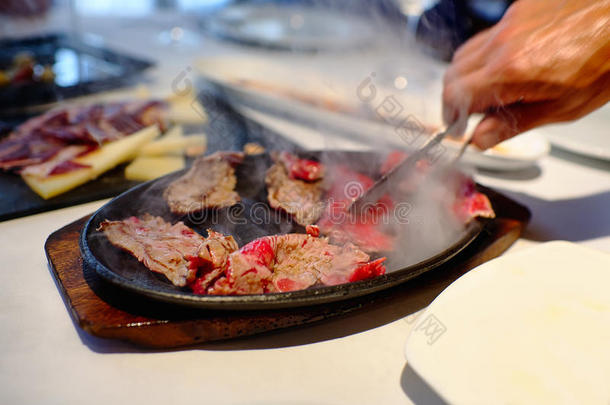 烹饪肉就在桌面客户端上，热烘烤片厚。 托里维亚的埃梅森·德拉科斯塔餐厅