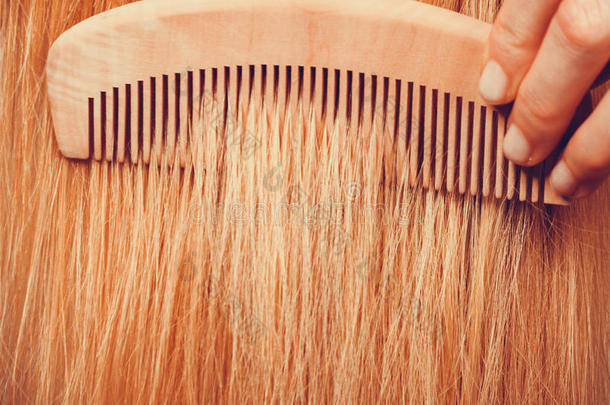 金发女人用梳子梳头发
