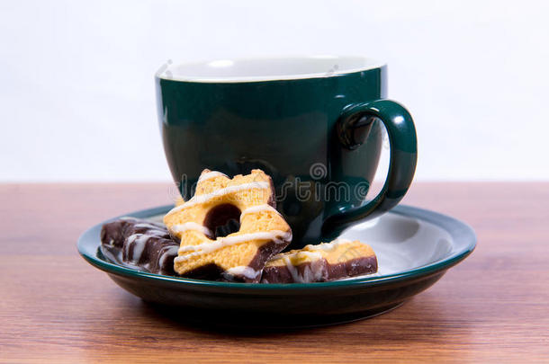 一杯香喷喷的红茶，在一个瓷杯和一个盘子上覆盖着巧克力的短面包-美味的早餐为你的<strong>最爱</strong>