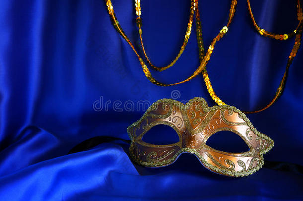 蓝色丝绸背景上的金色威尼斯面具
