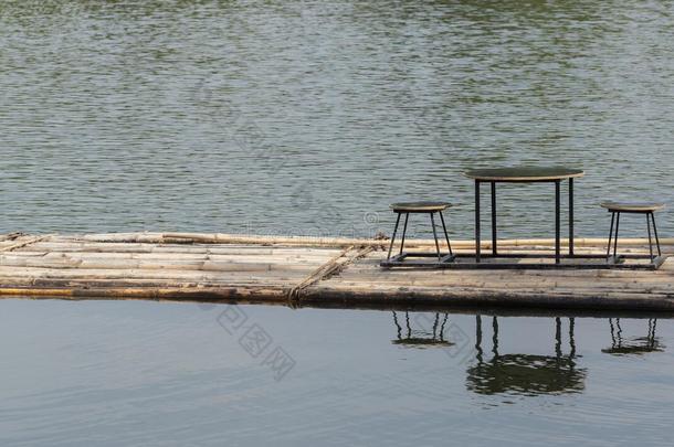 <strong>竹筏</strong>漂浮在河里，餐桌和椅子上