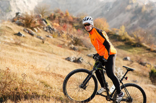 骑自行车的骑着橙色<strong>夹克</strong>的骑自行车的洛基山。 极限<strong>运动</strong>概念。 文本的空间。
