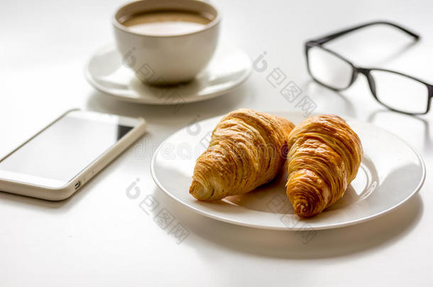 商人早餐，白色桌子上有咖啡和牛角面包