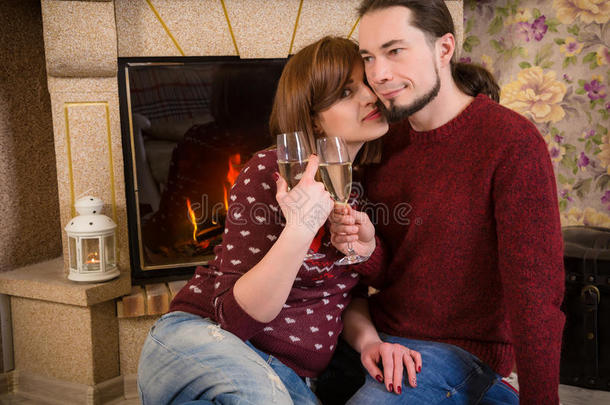 一对夫妇在壁炉附近一起喝一杯香槟