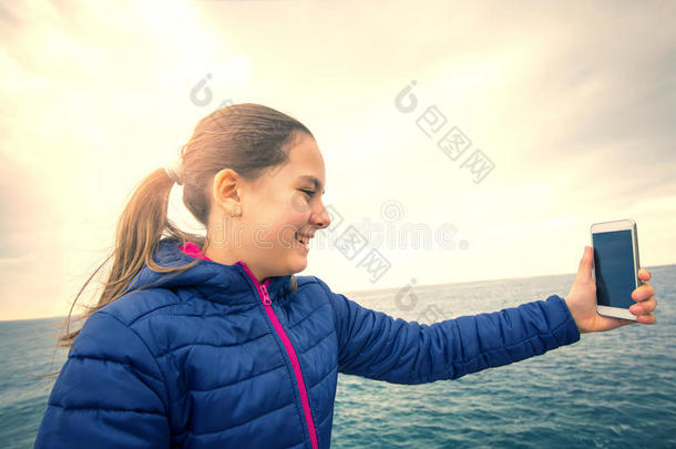 女孩拿着<strong>手机</strong>在海上自拍