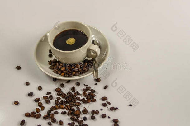 黑色咖啡在<strong>一个</strong>白色的杯子上，用<strong>勺子</strong>和溢出的咖啡豆