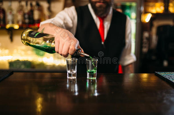 酒吧老板把酒精饮料倒在玻璃里