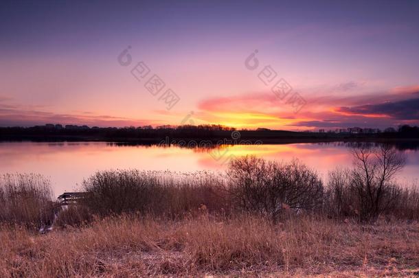 美丽的夕阳笼罩着春天的湖泊景观