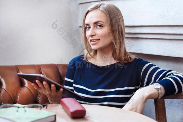 一个女人在咖啡馆里拿着平板电脑一个年轻的