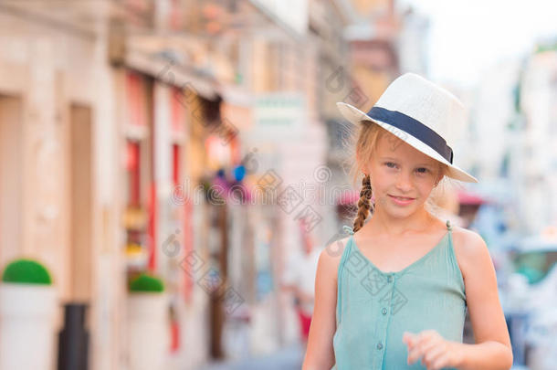 可爱的快乐小女孩户外在欧洲城市。 白种人孩子的肖像在欧洲享受暑假