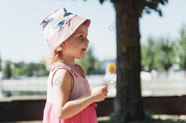 有趣的孩子用糖果棒棒糖，快乐的小女孩吃大
