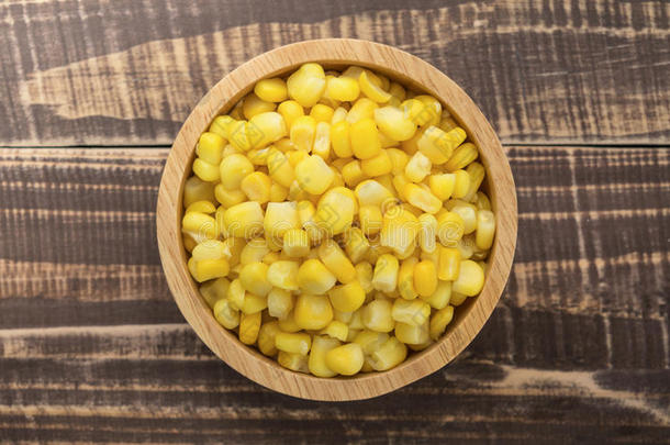 碗里有玉米种子，木桌上有成熟的玉米芯
