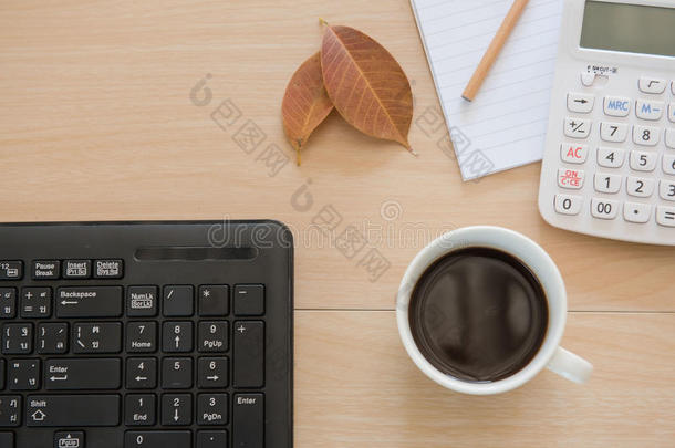 办公室的业务对象。 木制桌子上的杯子咖啡和键盘。