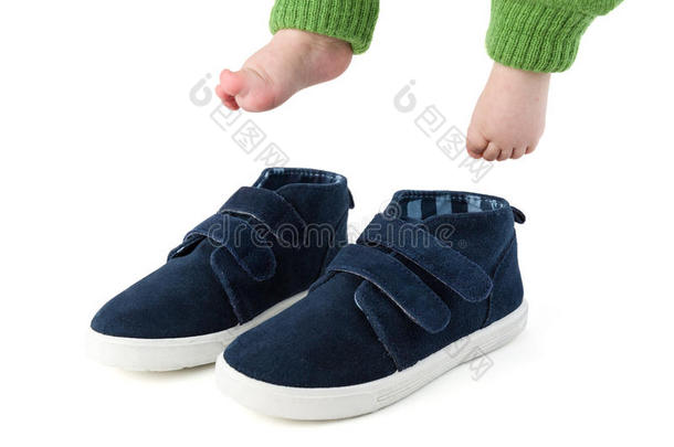 婴儿脚与太大的蓝色童鞋隔离在白色上
