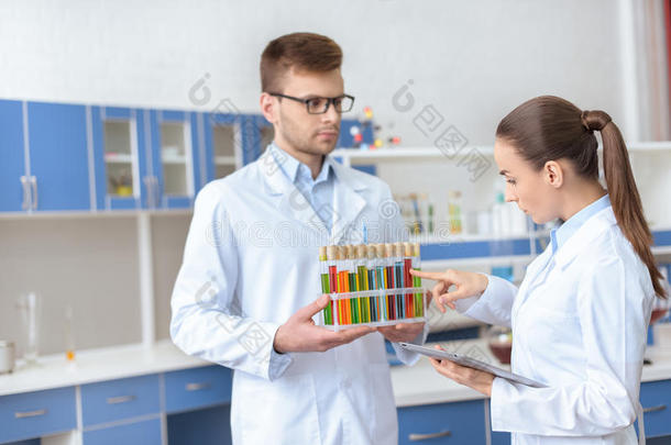 穿着白大衣的化学家在实验室用试剂检查试管