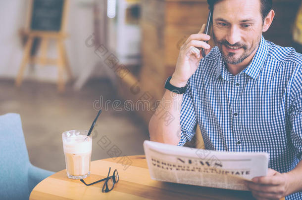 快乐的人在咖啡馆里读报纸