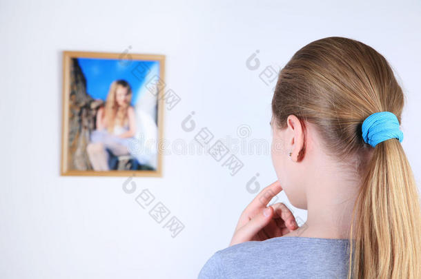 女孩专心地在墙上看照片