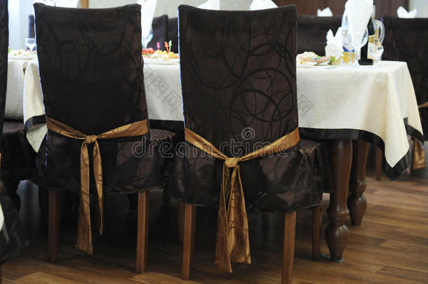在餐馆里用蝴蝶结铺着棕色的椅子