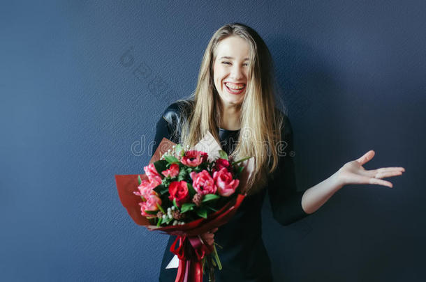 可爱的女孩带着一束红色郁金香。