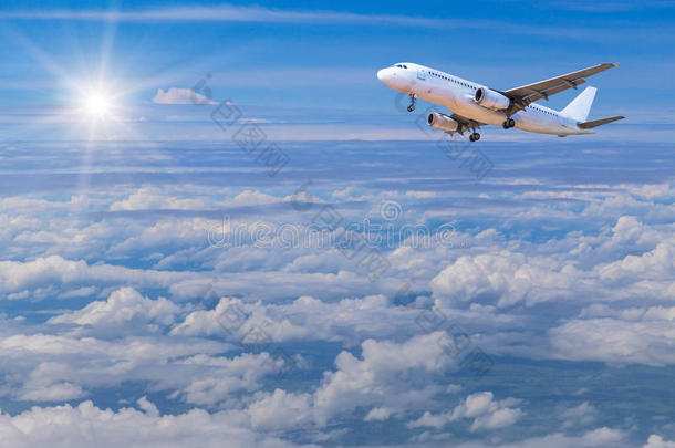 飞机随着阳光飞向白云上方的天空