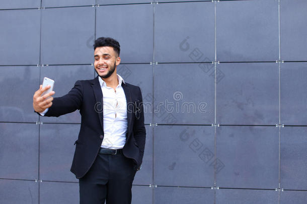 英俊的阿拉伯男人在商务中心自拍智能手机