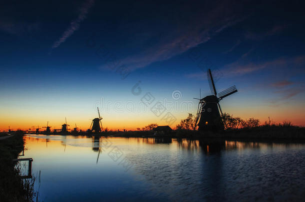 五颜六色的春天日落，传统的荷兰风车运河在罗特