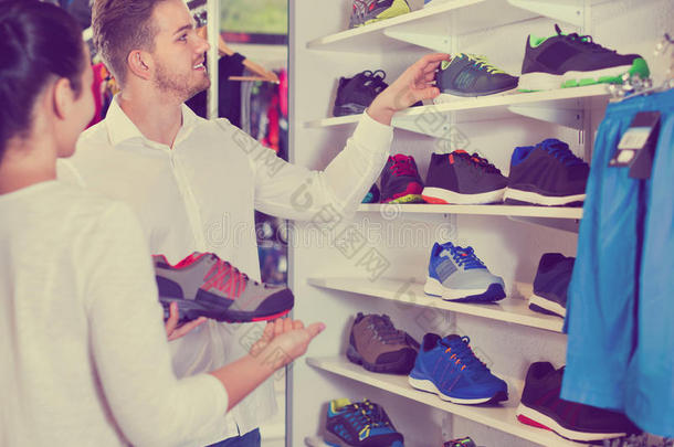 一对夫妇在体育商店检查各种运动鞋