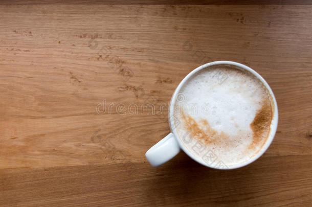 木制桌子背景上的咖啡杯俯视图
