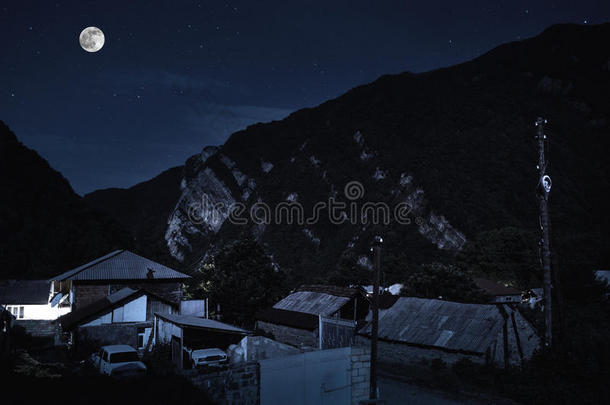 山坡上伊犁山村的美丽景观。 晚上在满月的光线下，大高加索山脉。 阿塞拜疆纳图